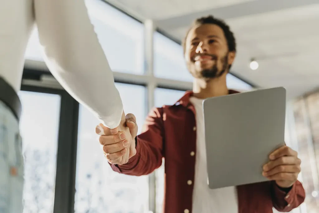Uścisk dłoni symbolizujący udany onboarding nowego pracownika dzięki automatyzacji procesów HR