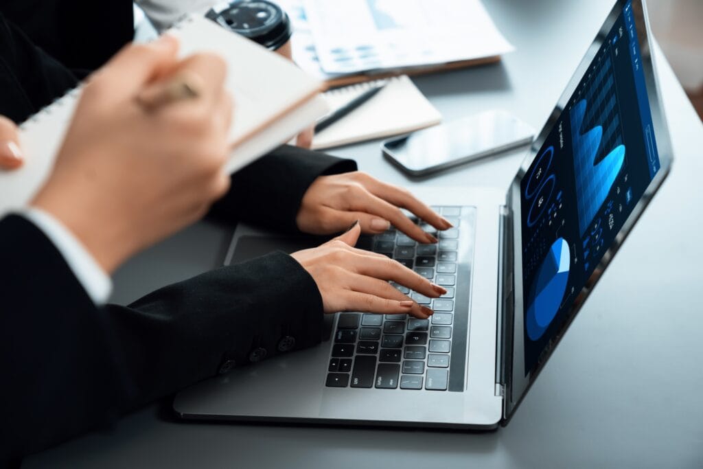 Analiza danych finansowych na laptopie podczas audytu IT w małej firmie