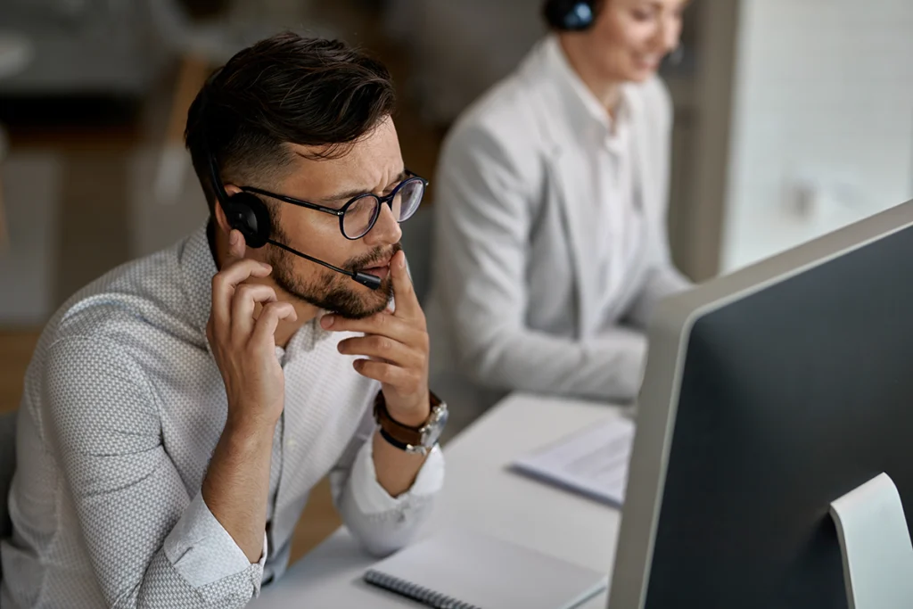 Konsultant call center prowadzący rozmowę telefoniczną, korzystający z workflow obsługi klienta skracającego czas odpowiedzi